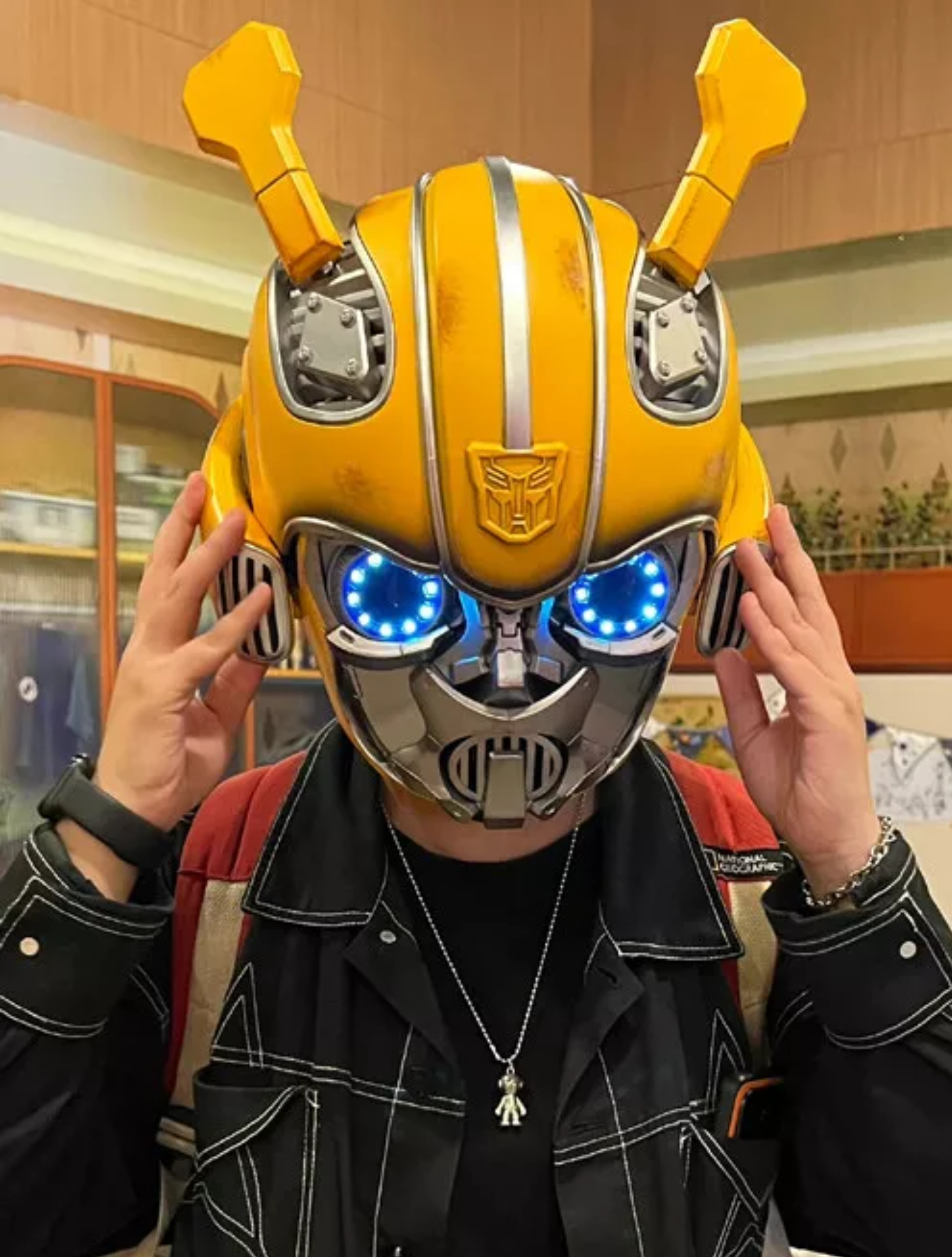Man wearing the Transformers Bumblebee helmet with the eyes lit